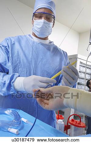 Stock Photo - Surgeon in operating room, low angle view. Fotosearch