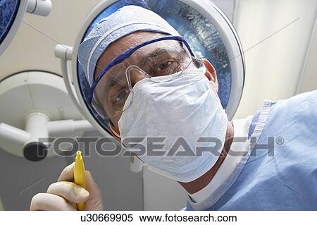 Stock Photography - Surgeon looking down, low angle view. Fotosearch