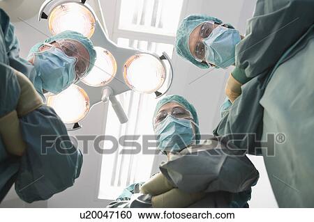 Surgeons in operating theatre looking down at patient, personal perspective View Large Photo Image Stock Image - Surgeons in operating theatre looking down at patient, personal perspective. Fotosearch