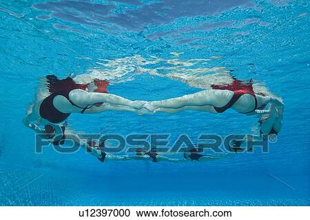 Stock Image - Synchronised swimmers form a circle. Fotosearch