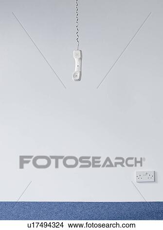 Picture - Telephone receiver hanging in empty room. Fotosearch