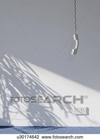 Telephone receiver hanging in empty room View Large Photo Image Stock Image - Telephone receiver hanging in empty room. Fotosearch