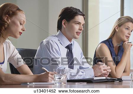 Three businesspeople sitting at business meeting View Large Photo Image Stock Image - Three businesspeople sitting at business meeting. Fotosearch