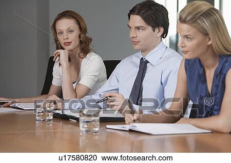 Three businesspeople sitting at business meeting View Large Photo Image Stock Image - Three businesspeople sitting at business meeting. Fotosearch