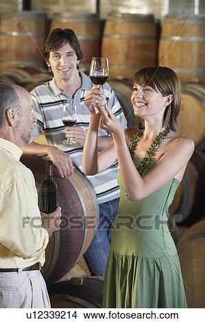 Three people wine-tasting beside wine casks View Large Photo Image Picture - Three people wine-tasting beside wine casks. Fotosearch