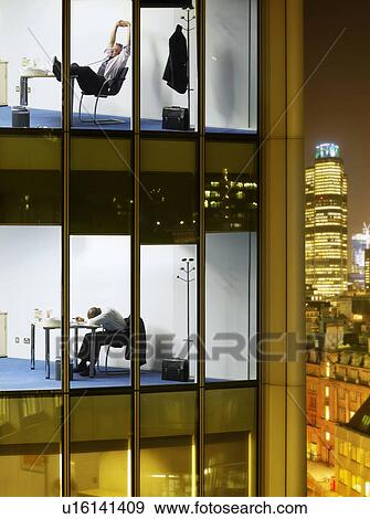 Stock Photo - Tired business men in offices, view from building exterior. Fotosearch