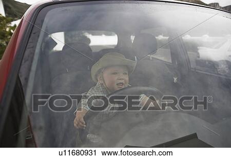 Stock Image - Toddler in the driving seat. Fotosearch