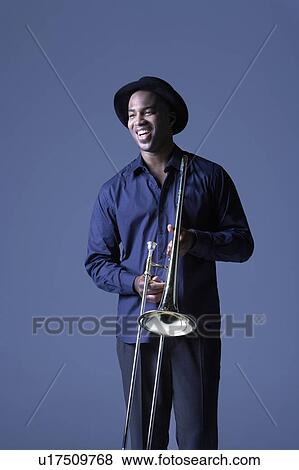 Trombone Player standing with hat, smiling View Large Photo Image Stock Photo - Trombone Player standing with hat, smiling. Fotosearch