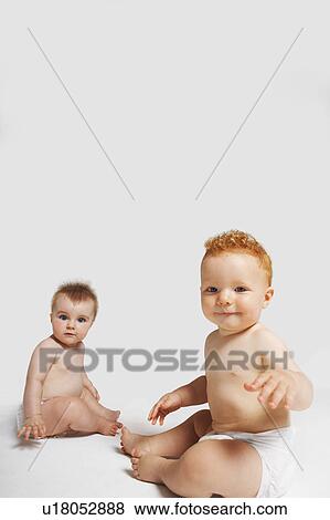 Two babies looking at camera View Large Photo Image Stock Photo - Two babies looking at camera. Fotosearch