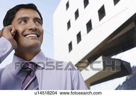 Picture - Two business men shaking hands on street. Fotosearch