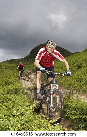 Two cyclists on track in countryside View Large Photo Image Stock Photograph - Two cyclists on track in countryside. Fotosearch