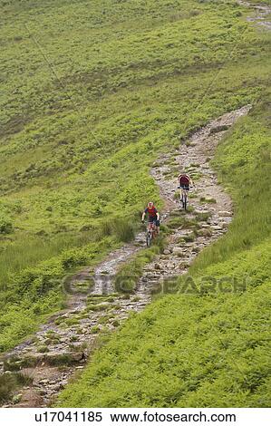 Two cyclists on track in countryside View Large Photo Image Stock Photography - Two cyclists on track in countryside. Fotosearch