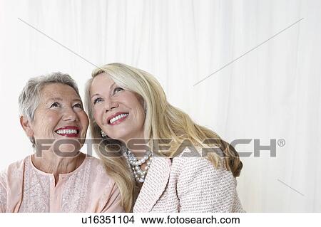 Two elegant senior woman in studio looking up, head and shoulders View Large Photo Image Picture - Two elegant senior woman in studio looking up, head and shoulders. Fotosearch