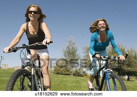 Two friends cycle side by side View Large Photo Image Stock Photo - Two friends cycle side by side. Fotosearch
