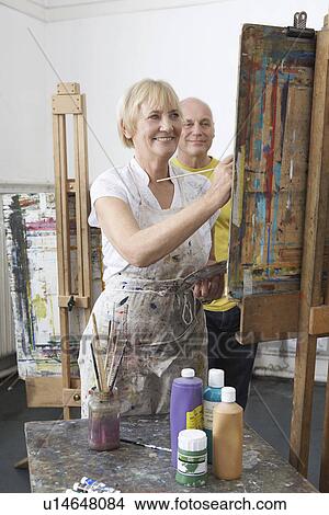 Two mature students painting at easels in art class View Large Photo Image Picture - Two mature students painting at easels in art class. Fotosearch