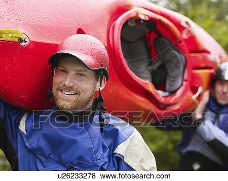 Two men carrying kayak, outdoors, portrait View Large Photo Image Stock Photo - Two men carrying kayak, outdoors, portrait. Fotosearch