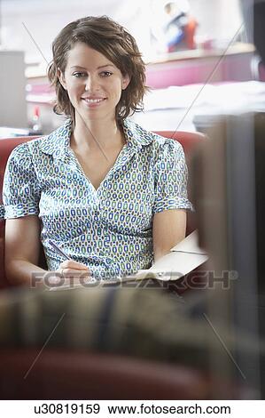Two office workers sitting on sofa in office, elevated view, focus on woman View Large Photo Image Stock Photo - Two office workers sitting on sofa in office, elevated view, focus on woman. Fotosearch