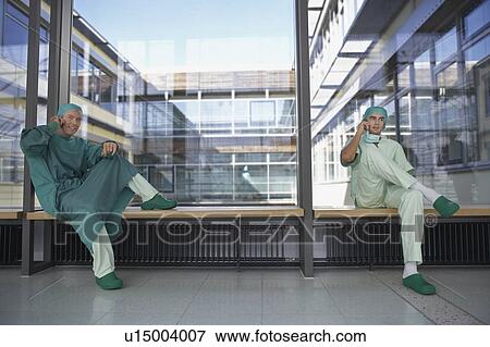 two surgeons in hospital corridor using mobile phones View Large Photo Image Stock Photo - two surgeons in hospital corridor using mobile phones. Fotosearch