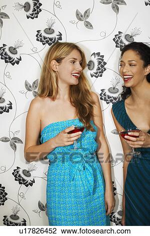 Two women Drinking Martinis by floral print wall View Large Photo Image Stock Image - Two women Drinking Martinis by floral print wall. Fotosearch
