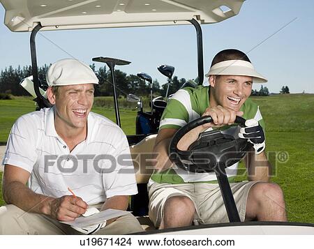 Picture - Two young male golfers sitting in cart, laughing. Fotosearch