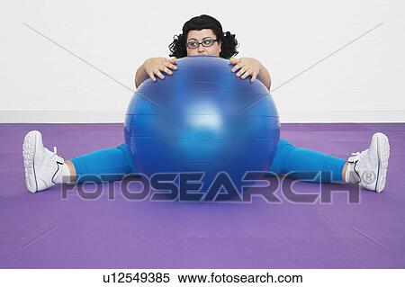 Stock Photography - Uninspired overweight Woman sitting Behind Exercise Ball. Fotosearch