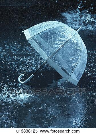 Stock Photography - Unused umbrella, lying on ground being rained upon. Fotosearch