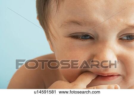 Stock Image - Upset Baby, finger in mouth. Fotosearch