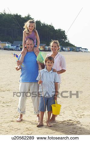 Stock Photo - Vacationing Family standing on Beach, portrait. Fotosearch