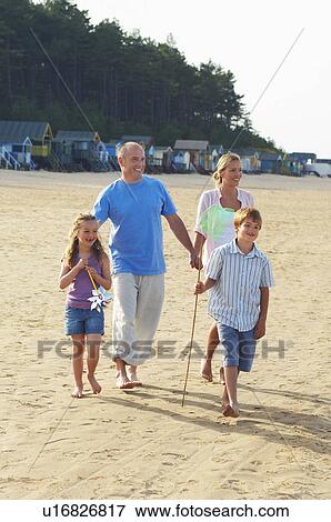 Stock Photo - Vacationing Family walking on Beach. Fotosearch
