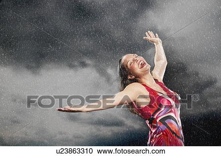 Woman, arms outstretched, smiling, standing in rain View Large Photo Image Stock Image - Woman, arms outstretched, smiling, standing in rain. Fotosearch