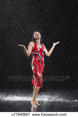 Woman, arms raised, smiling, standing in rain View Large Photo Image Stock Photo - Woman, arms raised, smiling, standing in rain. Fotosearch