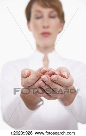Stock Photograph - Woman Cupping Her Hands, focus on hands. Fotosearch
