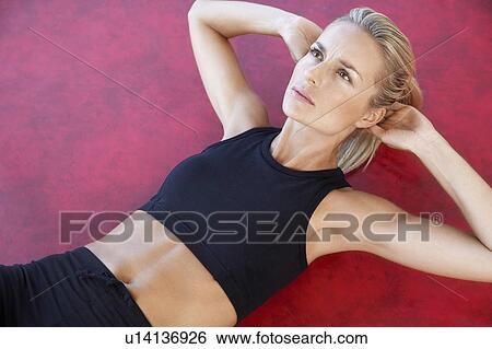 Stock Photograph - Woman Doing Sit-Ups, close up, high angle view. Fotosearch