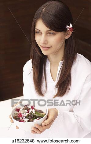 Woman holding bowl of flowers, portrait View Large Photo Image Stock Photo - Woman holding bowl of flowers, portrait. Fotosearch