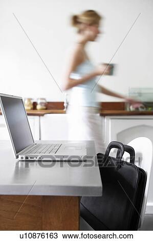 Woman in kitchen walking by laptop, focus on laptop View Large Photo Image Stock Image - Woman in kitchen walking by laptop, focus on laptop. Fotosearch