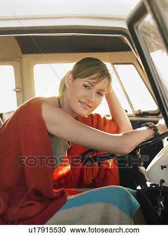 Woman in poncho sitting in front seat of van View Large Photo Image Stock Image - Woman in poncho sitting in front seat of van. Fotosearch