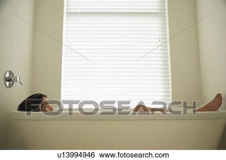 Woman lying in bath tub, side view View Large Photo Image Stock Photograph - Woman lying in bath tub, side view. Fotosearch