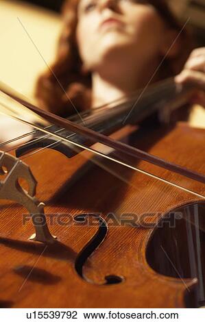 Stock Image - Woman Playing Double Bass, view from below, close-up. Fotosearch