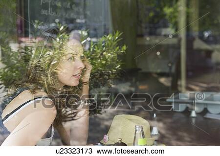 Stock Image - Woman sits in cafe, Amsterdam on the phone. Fotosearch