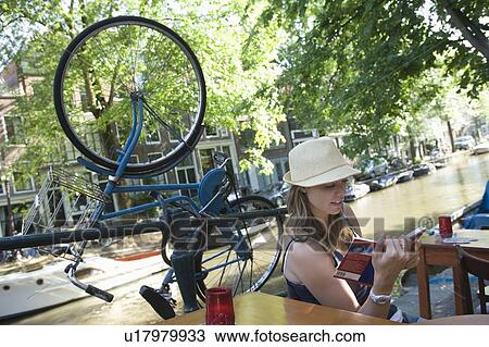 Woman sits reading guidebook on canalside, Amsterdam View Large Photo Image Stock Image - Woman sits reading guidebook on canalside, Amsterdam. Fotosearch