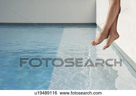 Woman sitting on edge of swimming pool, low section, side view View Large Photo Image Stock Photograph - Woman sitting on edge of swimming pool, low section, side view. Fotosearch