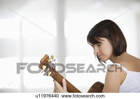 Woman sitting with accoustic guitar View Large Photo Image Stock Image - Woman sitting with accoustic guitar. Fotosearch