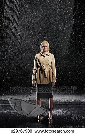 Stock Photo - Woman standing in rain, not Using Her Umbrella. Fotosearch