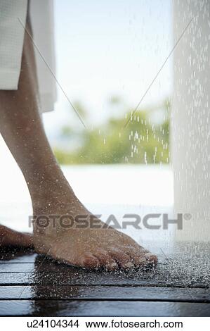 Picture - Woman standing under outdoor shower, low section. Fotosearch