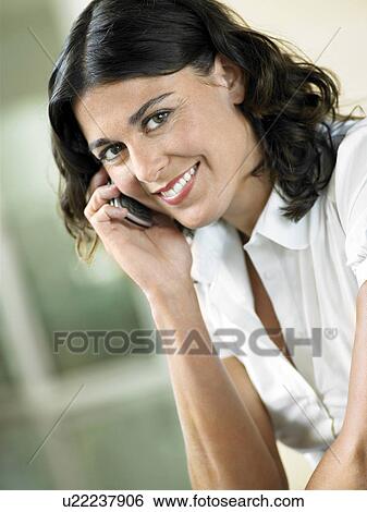 Stock Photograph - Woman Using Cell Phone indoors, portrait. Fotosearch