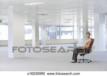 Woman Using Laptop in Empty Office Space View Large Photo Image Stock Image - Woman Using Laptop in Empty Office Space. Fotosearch
