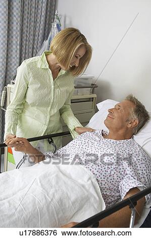 Woman visiting man in hospital View Large Photo Image Stock Photograph - Woman visiting man in hospital. Fotosearch