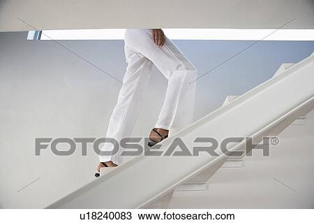 Woman walking up staircase indoors, low section View Large Photo Image Stock Image - Woman walking up staircase indoors, low section. Fotosearch