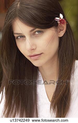 Stock Photo - Woman with flower in hair, portrait. Fotosearch