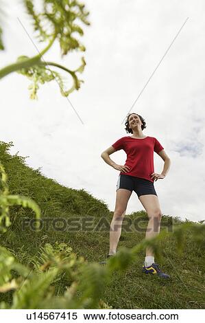 Stock Photography - Woman with hands on hips in countryside. Fotosearch